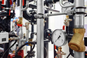 Equipment for a commercial boiler, including valves, meters, and piping.