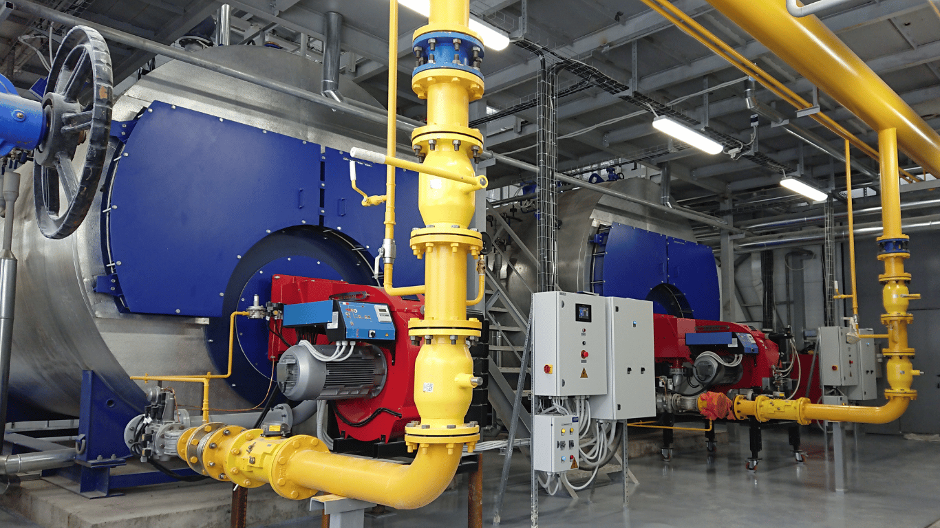 Industrial power plant boiler components with blue burners, yellow piping, red firing equipment, and control panels, showing boiler tubing, superheater tubes, water wall tubes, waterwall tubes, steam flow, tube temperature, tube metal, tube wall, heat transfer surfaces, combustion gas, and operating pressure during boiler start up.