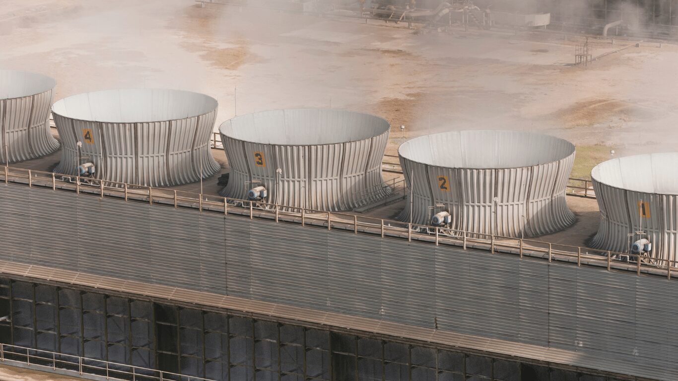 Industrial cooling tower systems with multiple fan units operating in a large facility designed for efficient cooling water circulation and optimized cycles of concentration. The image highlights modern tower systems that manage makeup water, tower water, and circulating water to improve heat transfer efficiency, reduce energy consumption, and maintain stable water quality through controlled cooling tower cycles and advanced treatment program strategies.