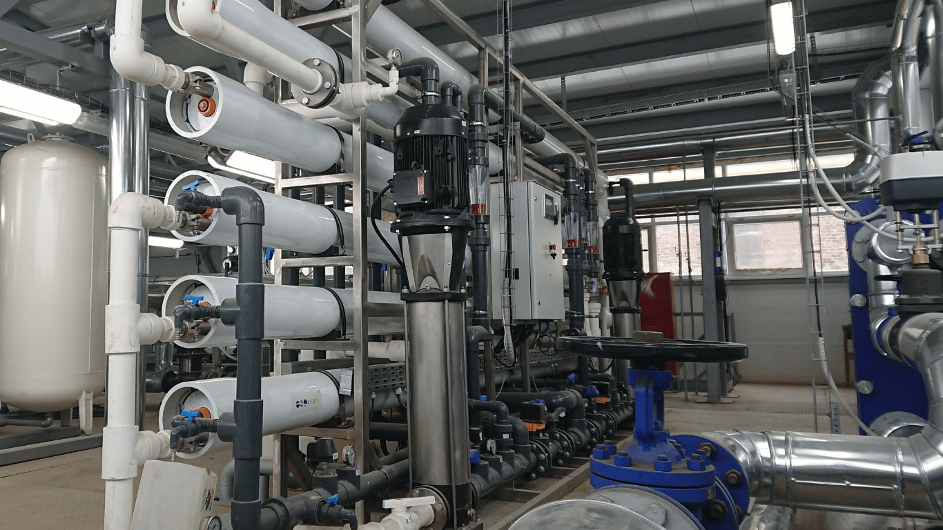 Industrial reverse osmosis system with RO membranes, dosing pump, pipes, and water treatment equipment for antiscalant dosage.