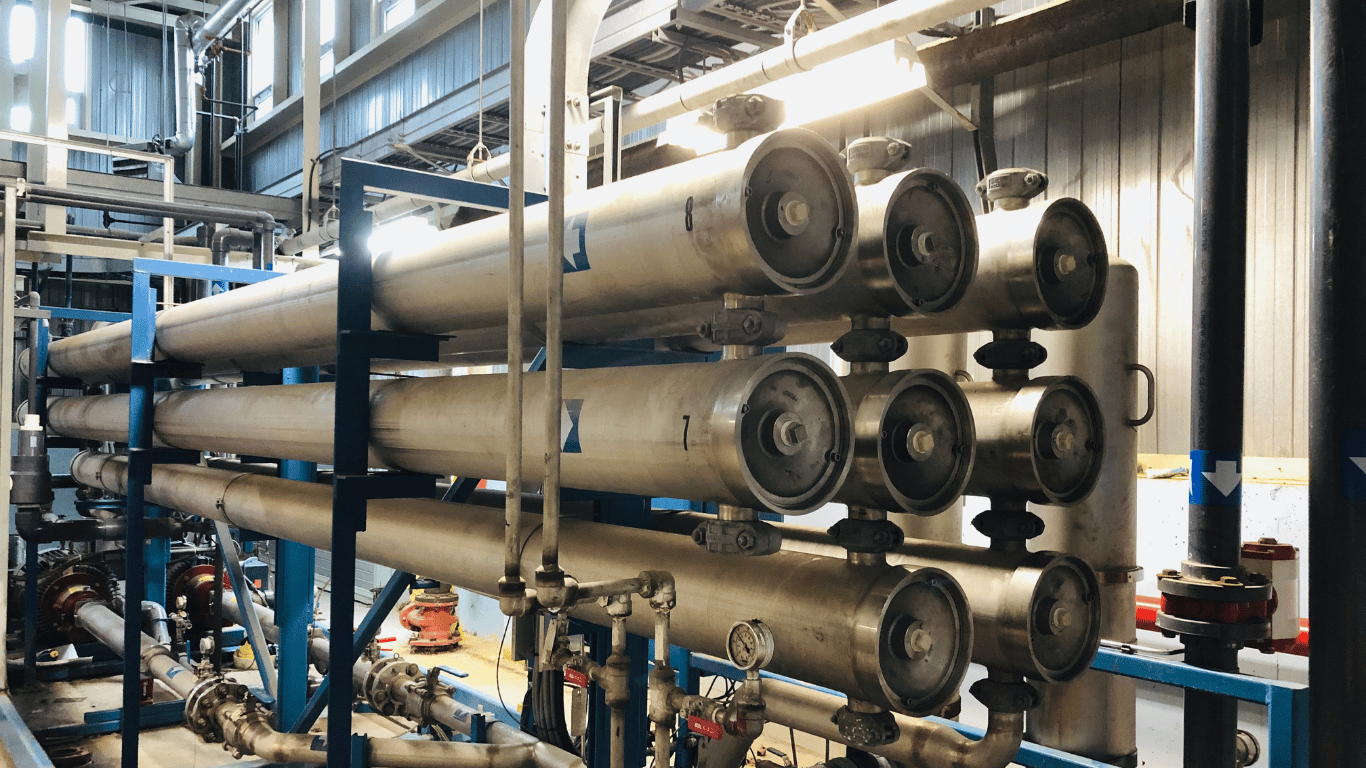 Industrial reverse osmosis system with membrane housings, pipes, valves, and equipment used in a water treatment process.